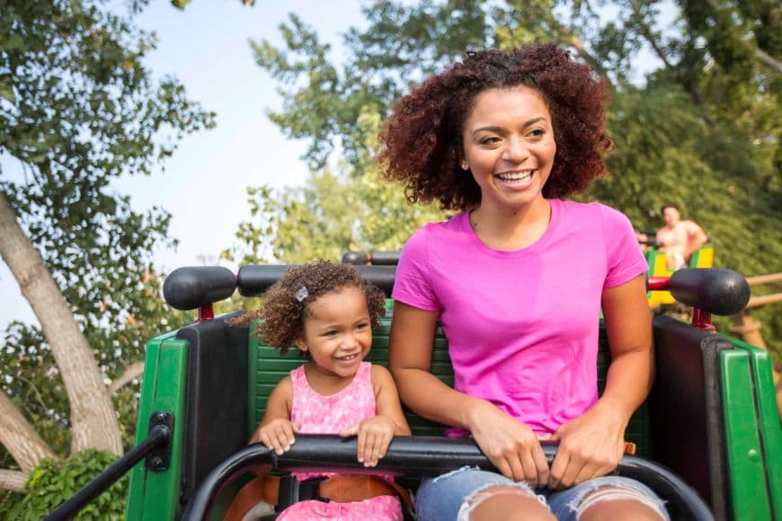 A mother and daughter on a kids roller coaster.