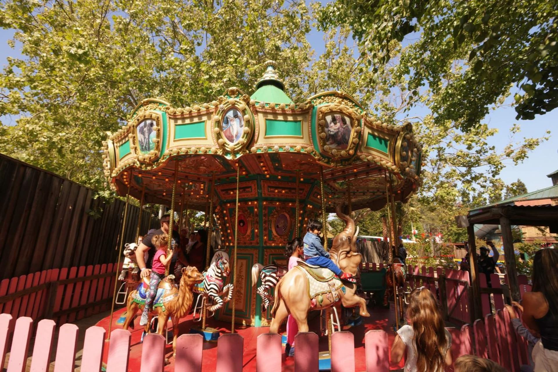 Families riding the Seaport Carousel at Six Flags Discovery Kingdom, enjoying the classic amusement ride.