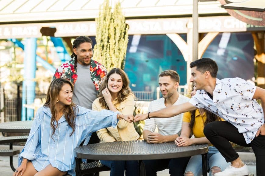 Group of guests standing and sitting around a table