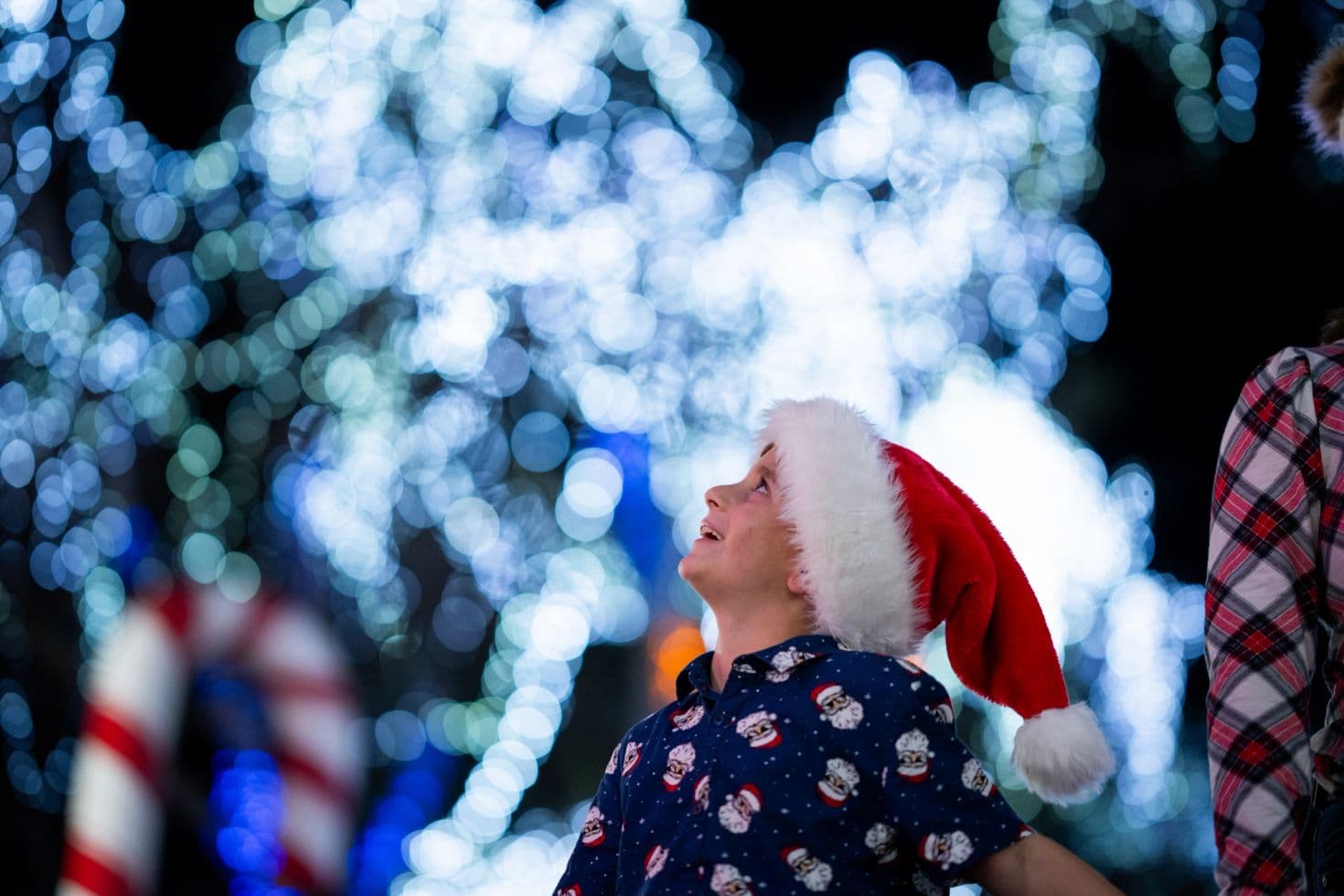 Kid looking up at the holiday lights