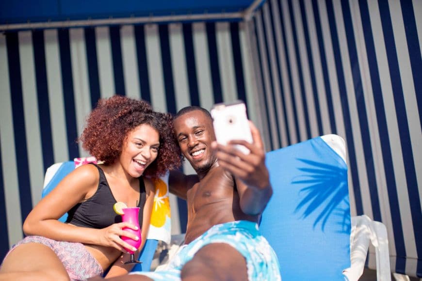 A couple taking a selfie while relaxing in a cabana at a waterpark.