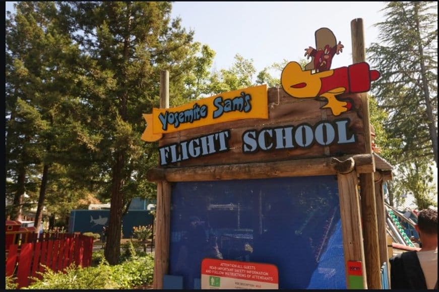 The Yosemite Sam's Flight School sign which is an adventure ride for toddlers at Six Flags Discovery Kingdom.