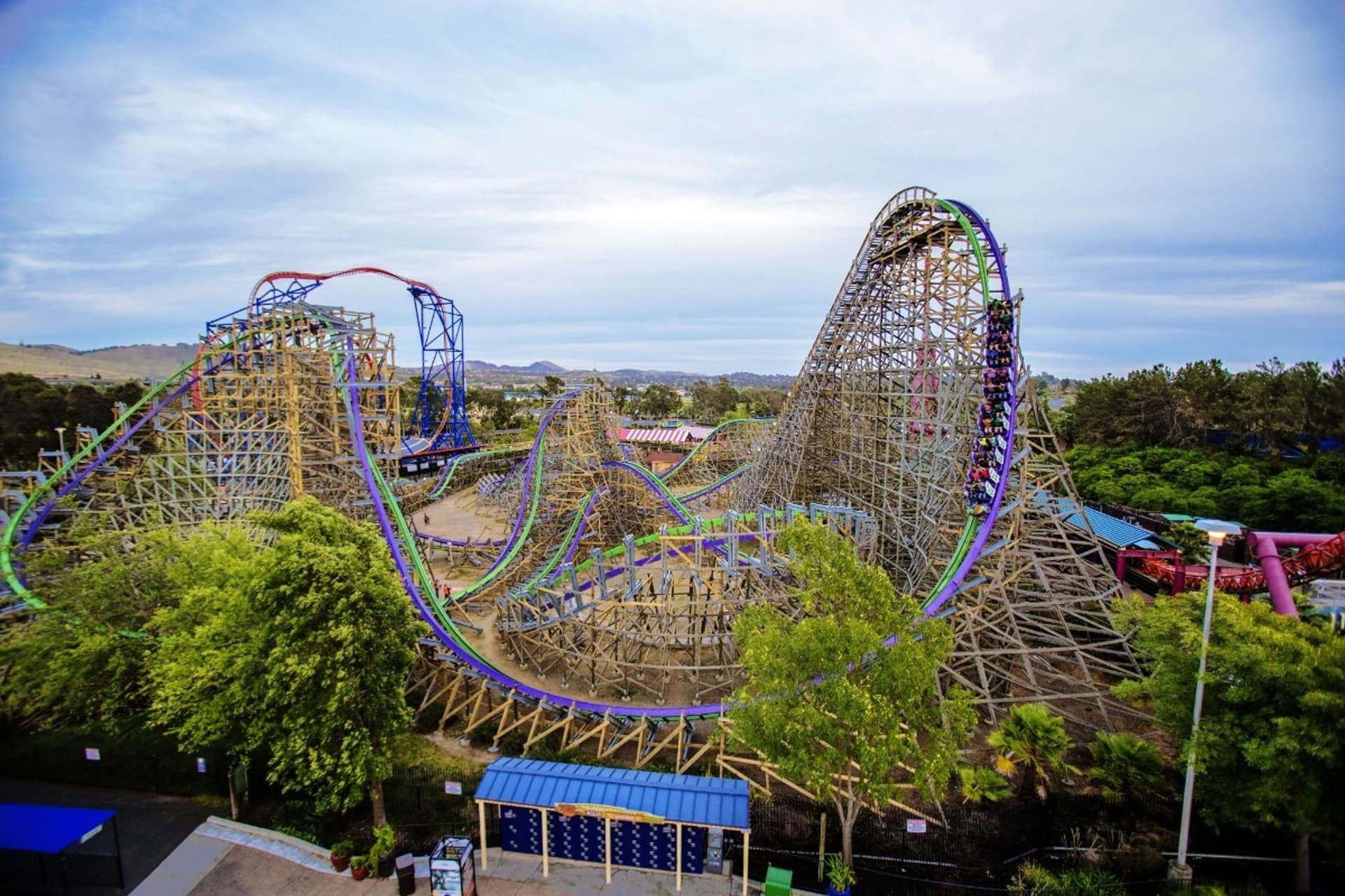 An aerial shot of Six Flags Discovery Kingdom's THE JOKER roller coaster showing guests ascending to the top of the ride.