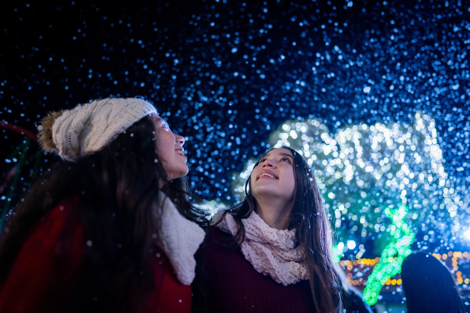 Two girls looking up at the snow falling down