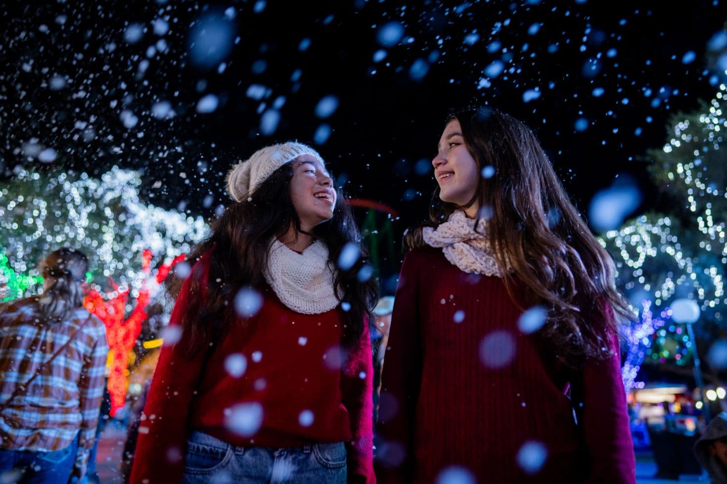Two girls smiling as snow falls