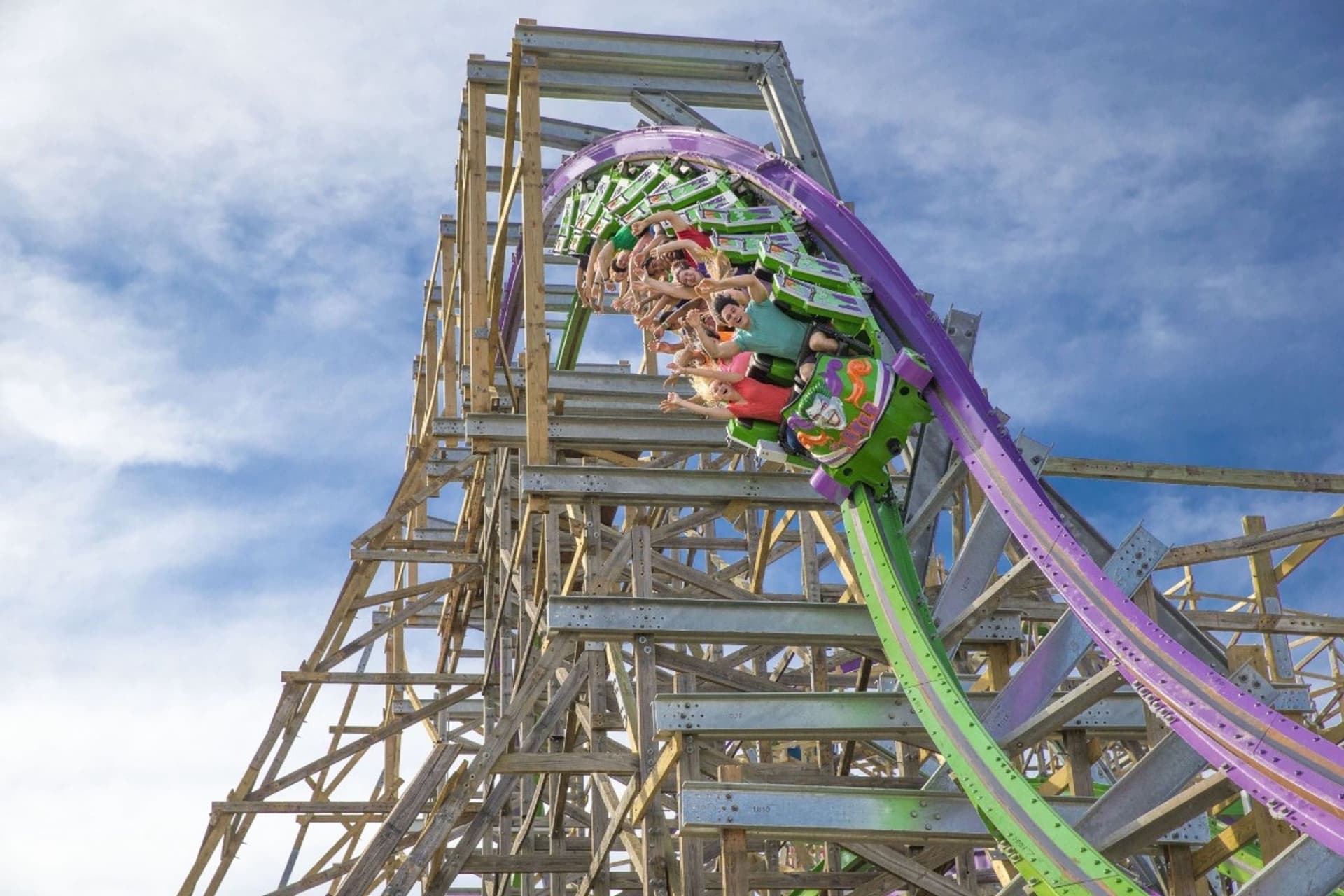 Guests coming out of a corkscrew of THE JOKER roller coaster leading into a descent and more thrills.