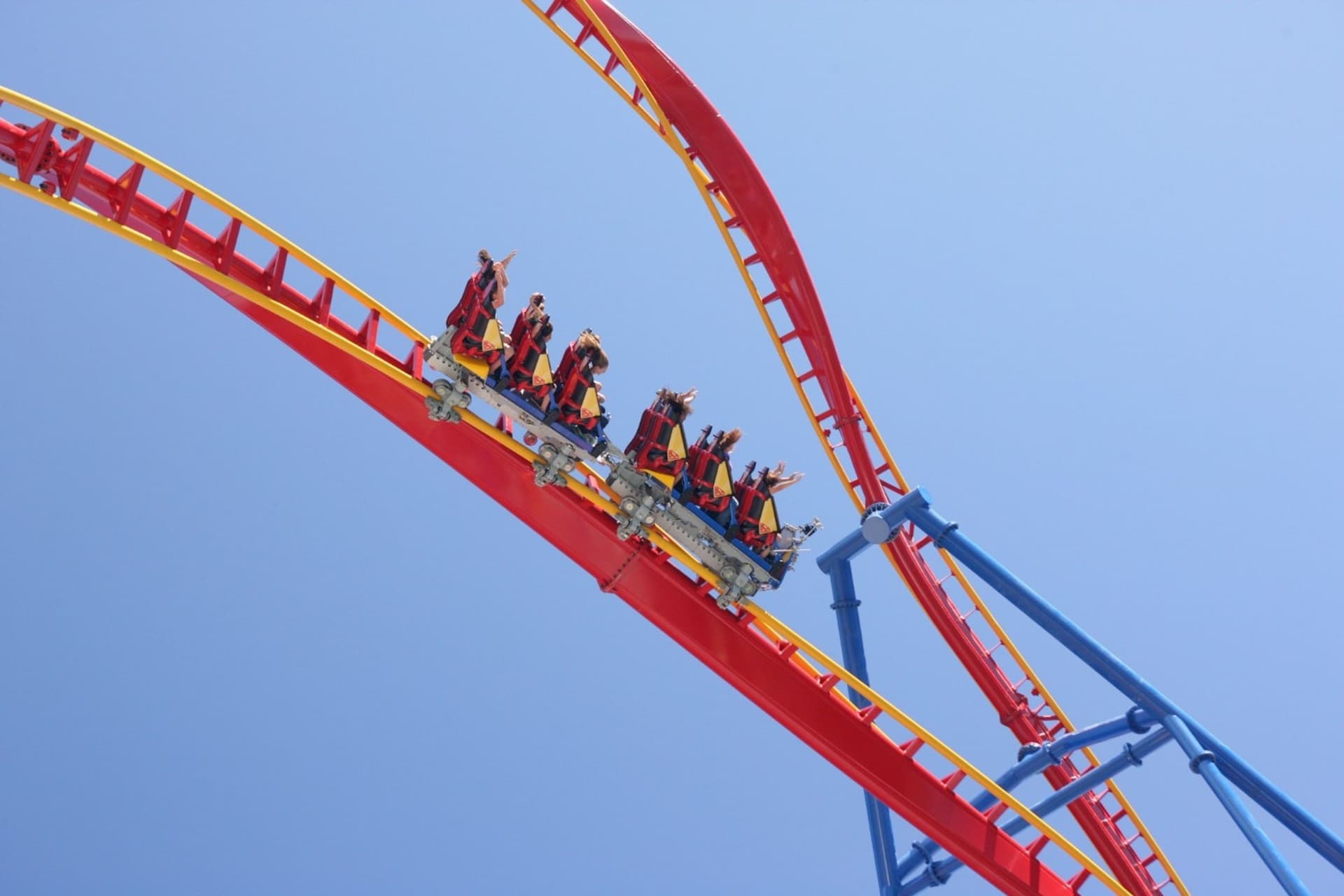 Thrill seekers with their hands up having fun riding SUPERMAN Ultimate Flight at Six Flags Discovery Kingdom.